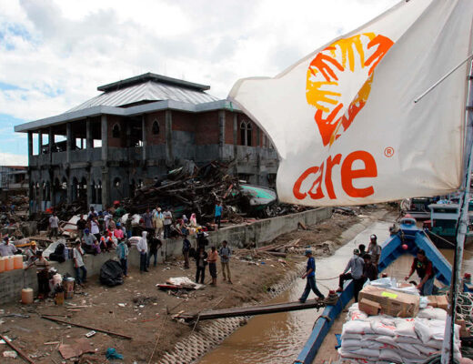 Indonesia-mobile-1000-Aceh-tsunami-CARE-flag-flaps-over-people-unloading-boat-josh-estey-e1715047656170